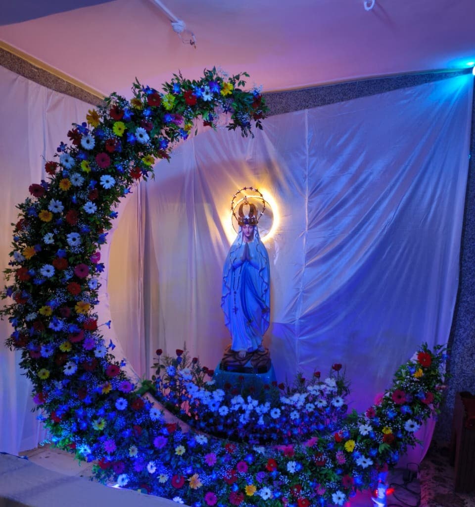 The statue of Our Lady of Lourdes in the parish, set within a floral crescent