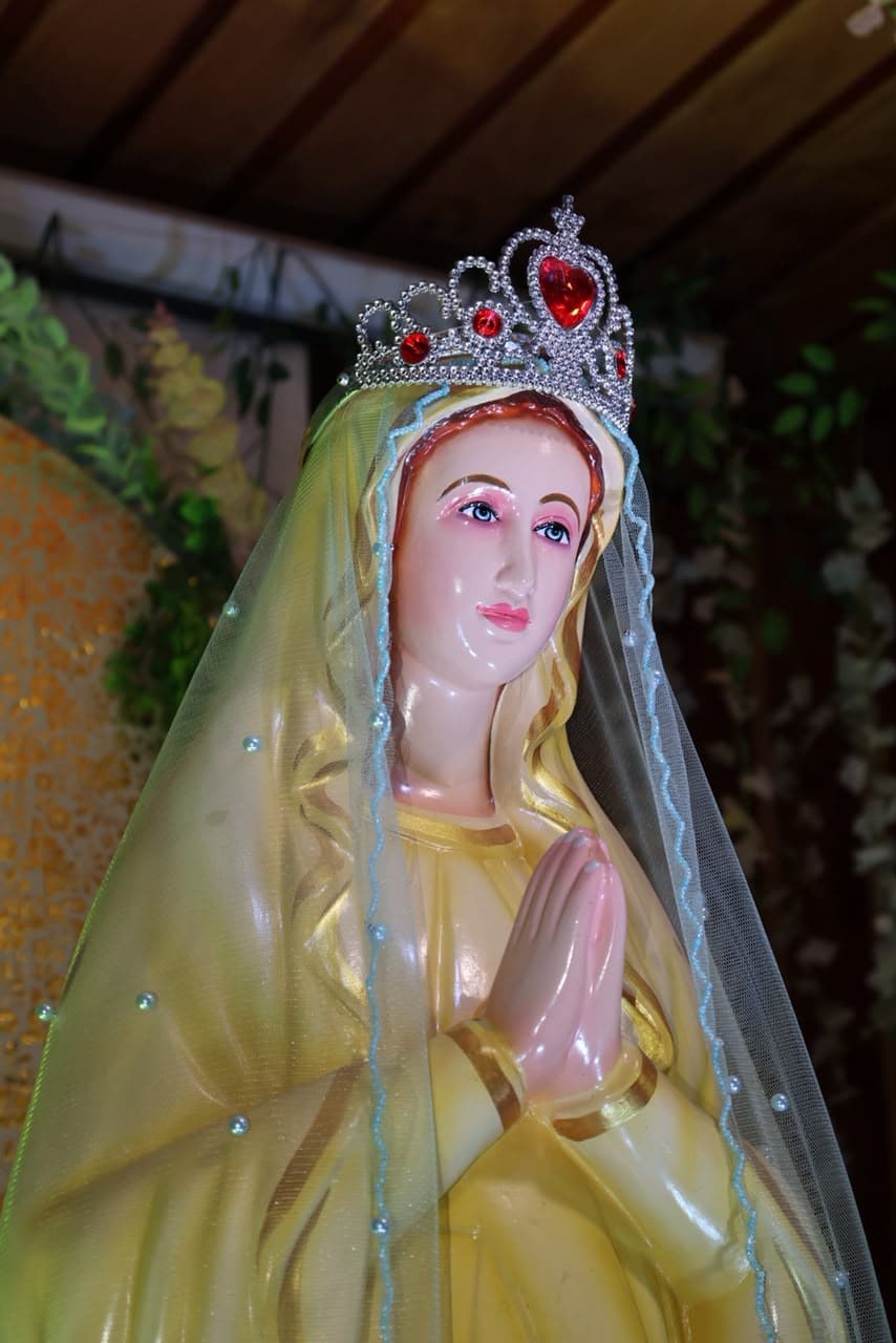 The statue of Our Lady at the parish shrine, crowned and veiled, her hands joined in prayer